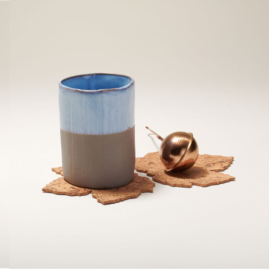 a coffee cup sitting next to a cup of coffee