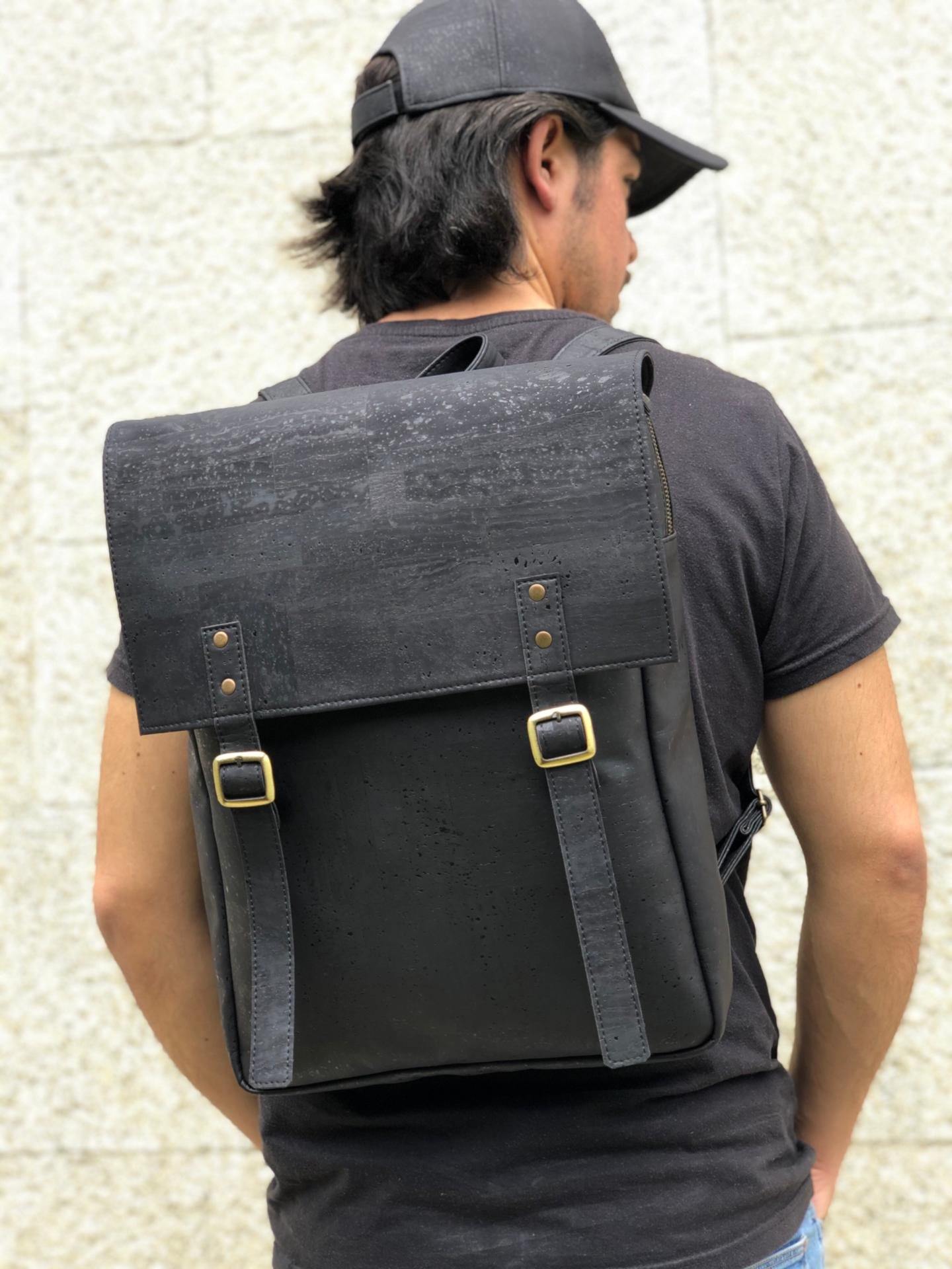 a man standing next to a black suitcase